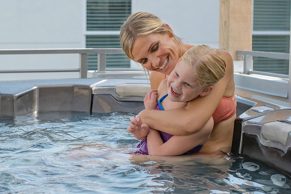 vrouw en kind genieten samen in bullfrog spa jacuzzi met jetpaks persoonlijk instelbaar westspa